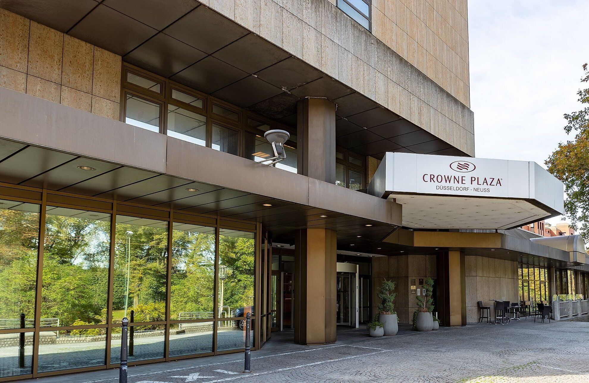 Ein modernes Gebäude mit einem Schild, auf dem 'CROWNE PLAZA DÜSSELDORF - NEUSS' steht.