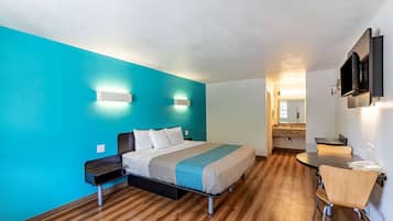 Une chambre d’hôtel moderne, équipée d’un lit, d’un bureau et d’une chaise.