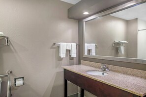 A bathroom with a sink, mirror, towel rack, and toilet paper holder. - Red Roof Inn Columbia, TN (Columbia)