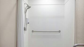 A shower with a handheld showerhead and a grab bar.