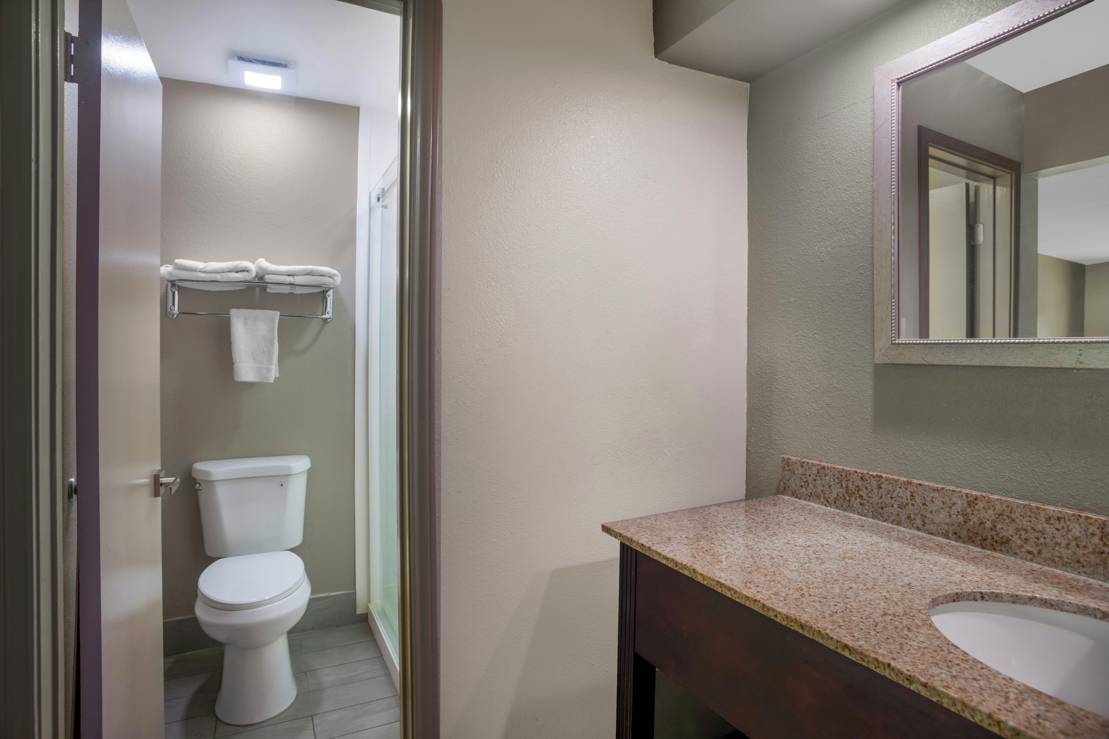 Un baño con inodoro, lavabo y toallero.