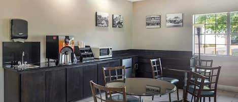 A restaurant with a bar area, seating, and wall art.
