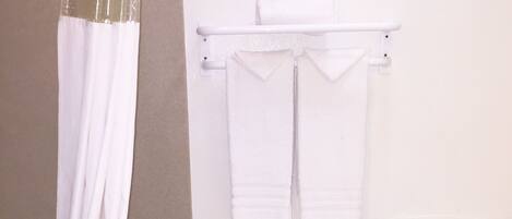 A bathroom with a bathtub, a toilet, and a shower curtain.