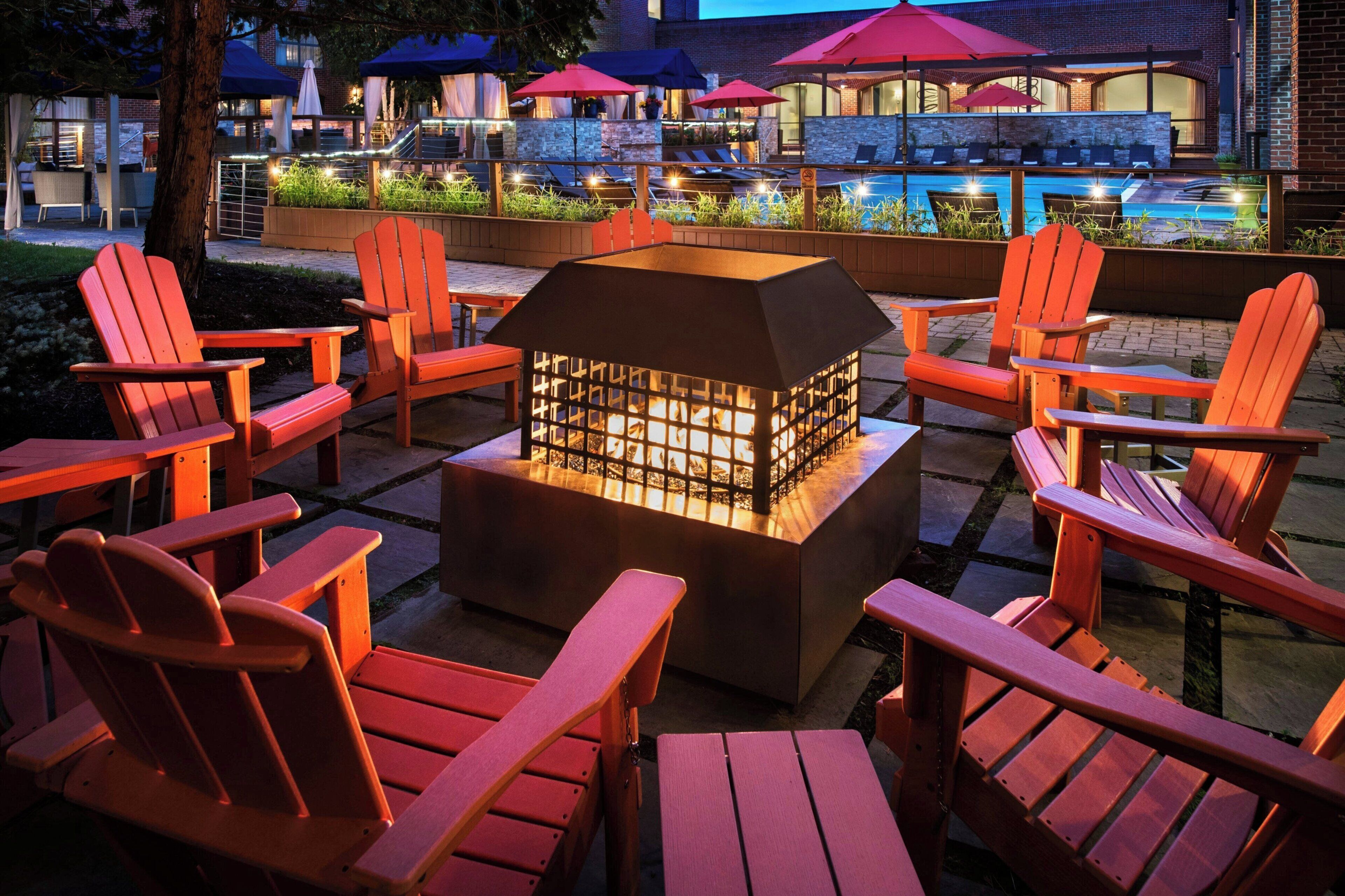 A patio area with Adirondack chairs and a central fire feature.