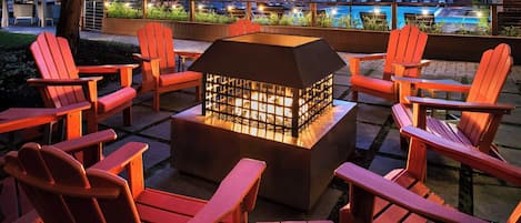 A patio area with Adirondack chairs and a central fire feature.