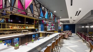 A modern bar area with a long counter, bar stools, and a variety of bottles and glasses. - Providence Marriott Downtown (Providence)