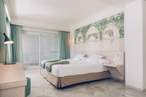 Een moderne hotelkamer met een groot bed, een bureau en uitzicht op de omgeving.