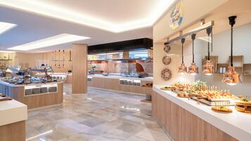 Eine moderne Hotellobby mit einer zentralen Rezeption, einem Frühstücksbuffet mit verschiedenen Speisen und einem sauberen, polierten Boden.