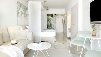 A modern, minimalist living room with a sofa, a coffee table, and a TV mounted on the wall.