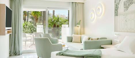 A modern hotel room with a balcony, a sofa, a bed, and a TV.