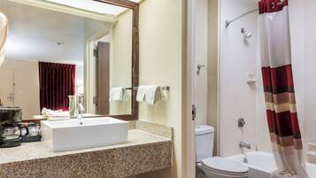 Une salle de bain équipée d’un lavabo, d’un miroir, de toilettes et d’une douche.