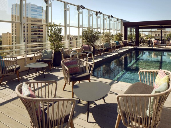 A rooftop terrace with a pool, wicker furniture, and large windows offering city views. - Pullman La Pléiade Montpellier Centre (Montpellier)