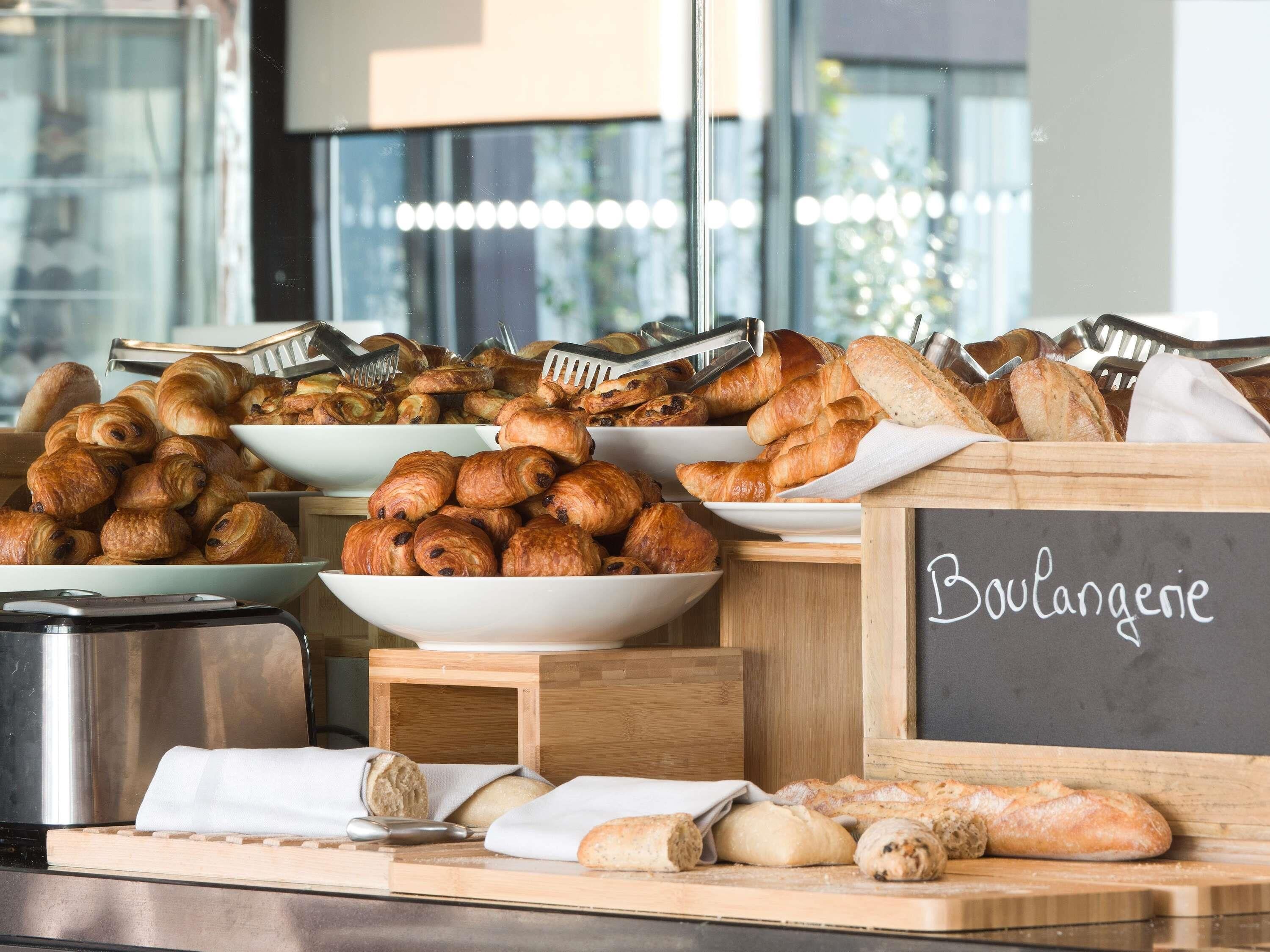 Una exhibición de productos de panadería variados, como cruasanes y barras de pan, con un letrero que dice 'Boulangerie'.