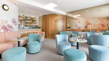 A modern lounge area with plush seating, a bar, and a decorative wall.