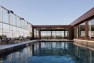 Una piscina cubierta, una piscina al aire libre de temporada, tumbonas
