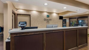 A hotel reception desk with a digital POS system, a computer, and a sign that reads "Quality Inn." - Quality Inn Marysville (Marysville)
