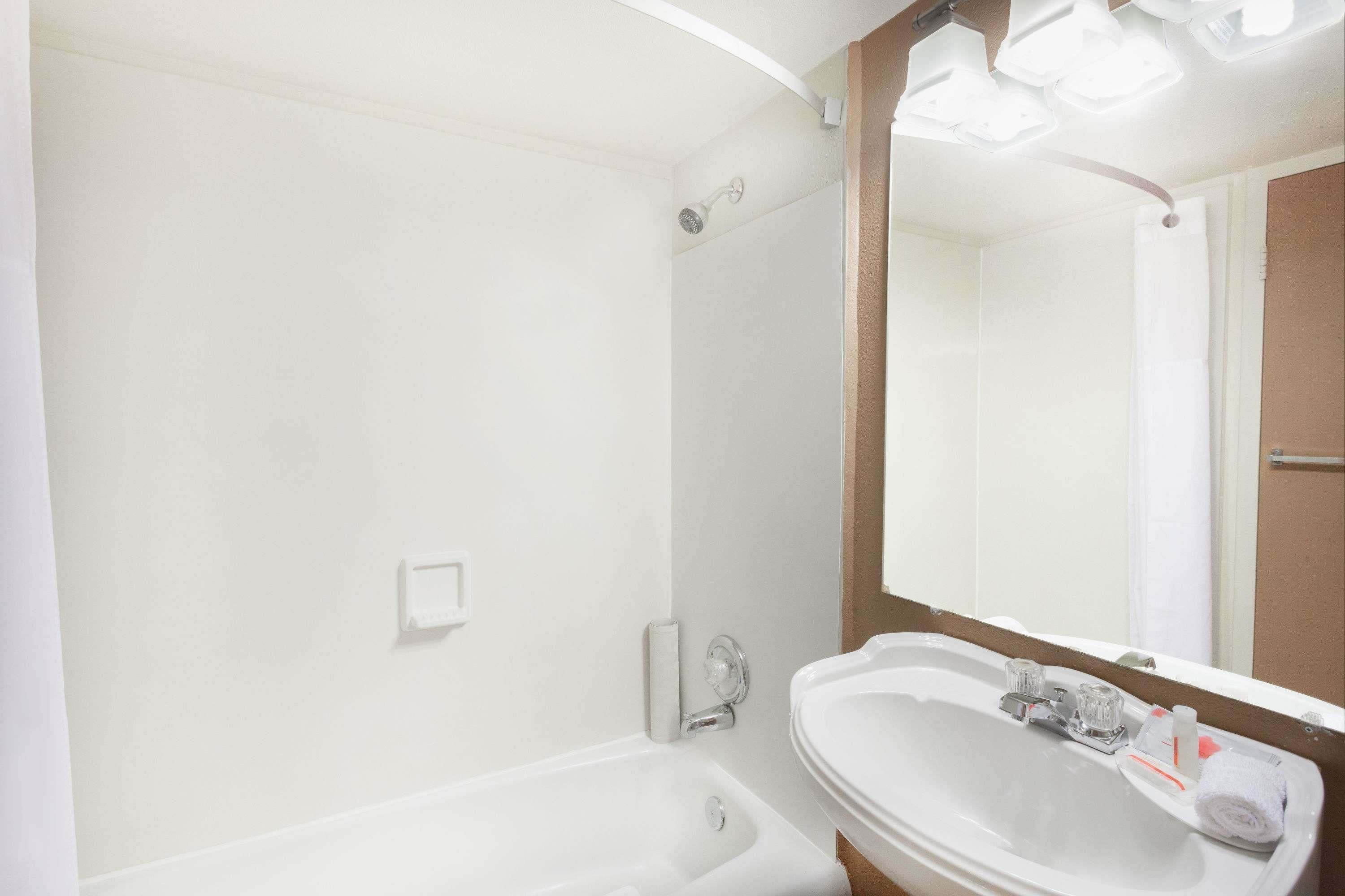 Une salle de bain avec un lavabo blanc, un miroir et une douche.