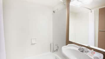 Une salle de bain avec un lavabo blanc, un miroir et une douche.