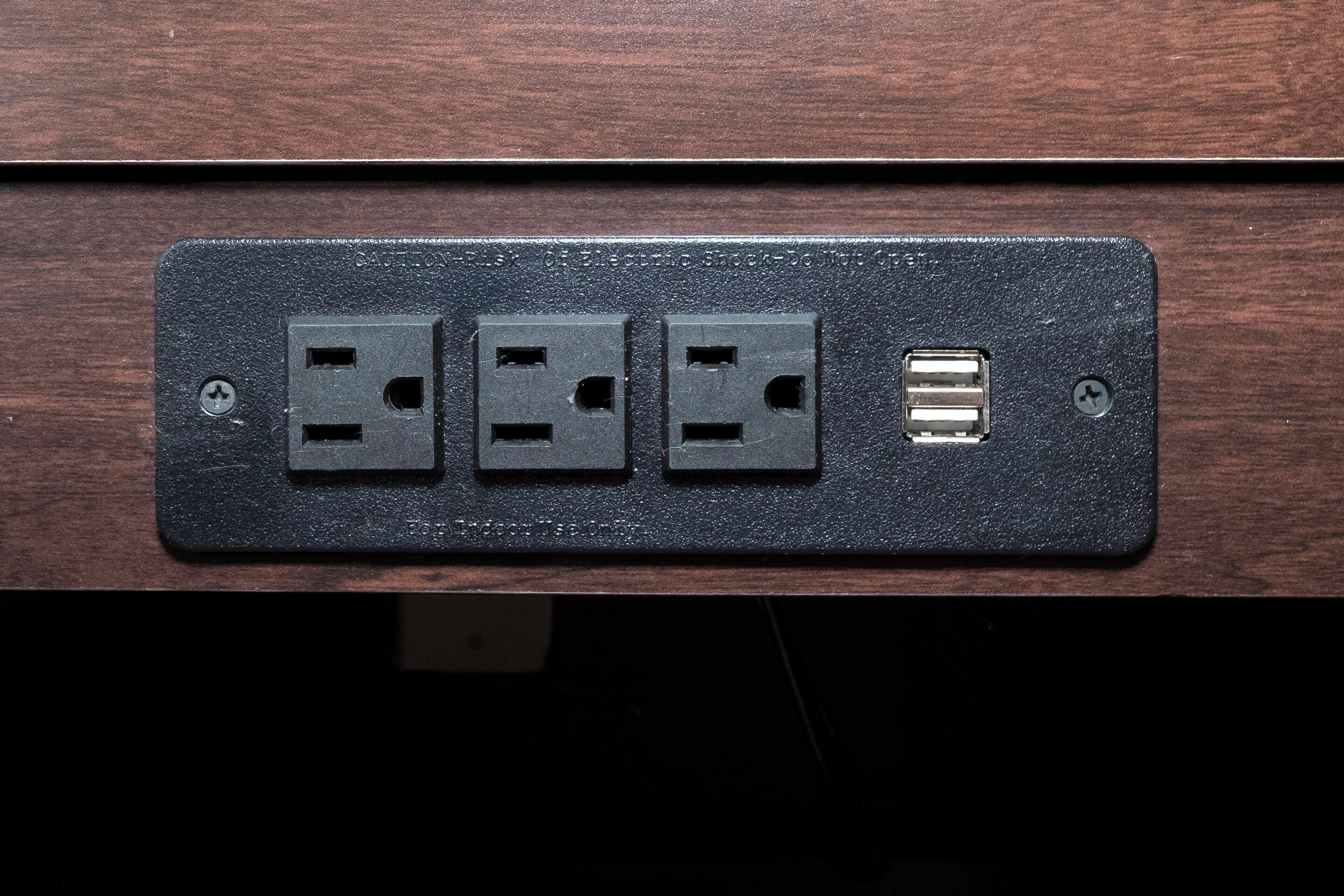 Eine an der Wand montierte Steckdose mit drei Standardsteckplätzen und einem USB-Anschluss.