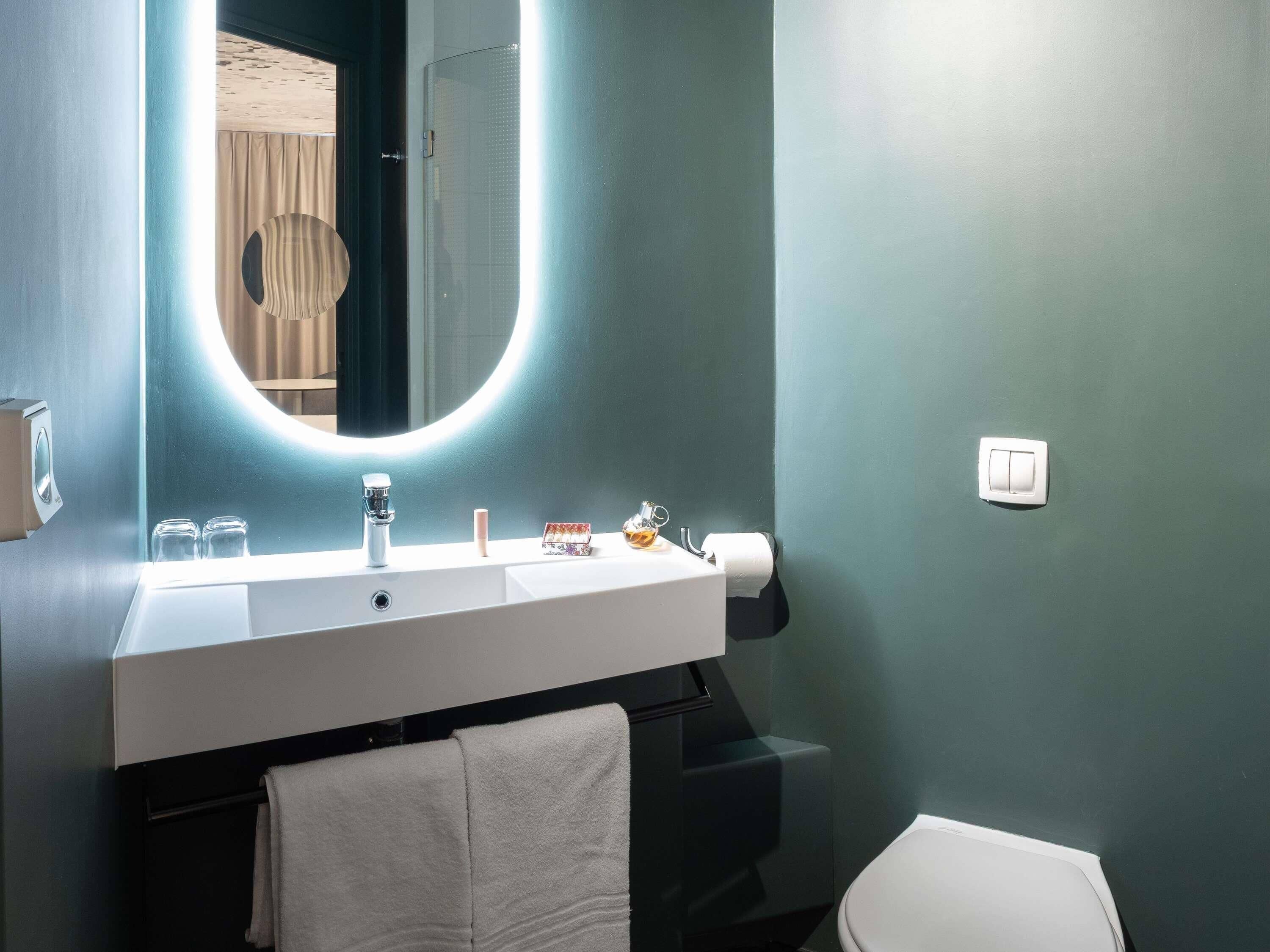 Ein Badezimmer mit Waschbecken, Spiegel und Toilette.