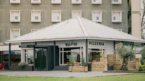 Eine Pizzeria mit modernem Design, mit Flachdach und großen Fenstern.