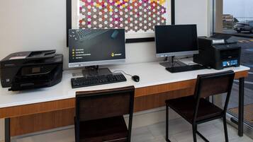 A workspace with two monitors, a printer, and a keyboard.