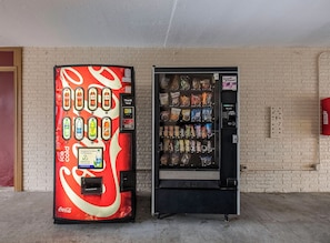 Two vending machines, one with a Coca-Cola design and the other with snacks. - Red Roof Inn Florence - Civic Center (Florence)