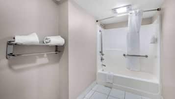 Un bagno con vasca, doccia e porta asciugamani con asciugamani.