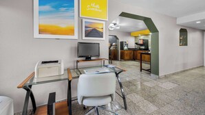 A modern office space with a glass desk, a printer, a computer monitor, and framed pictures on the wall. - Days Inn by Wyndham Raleigh Midtown (Raleigh)