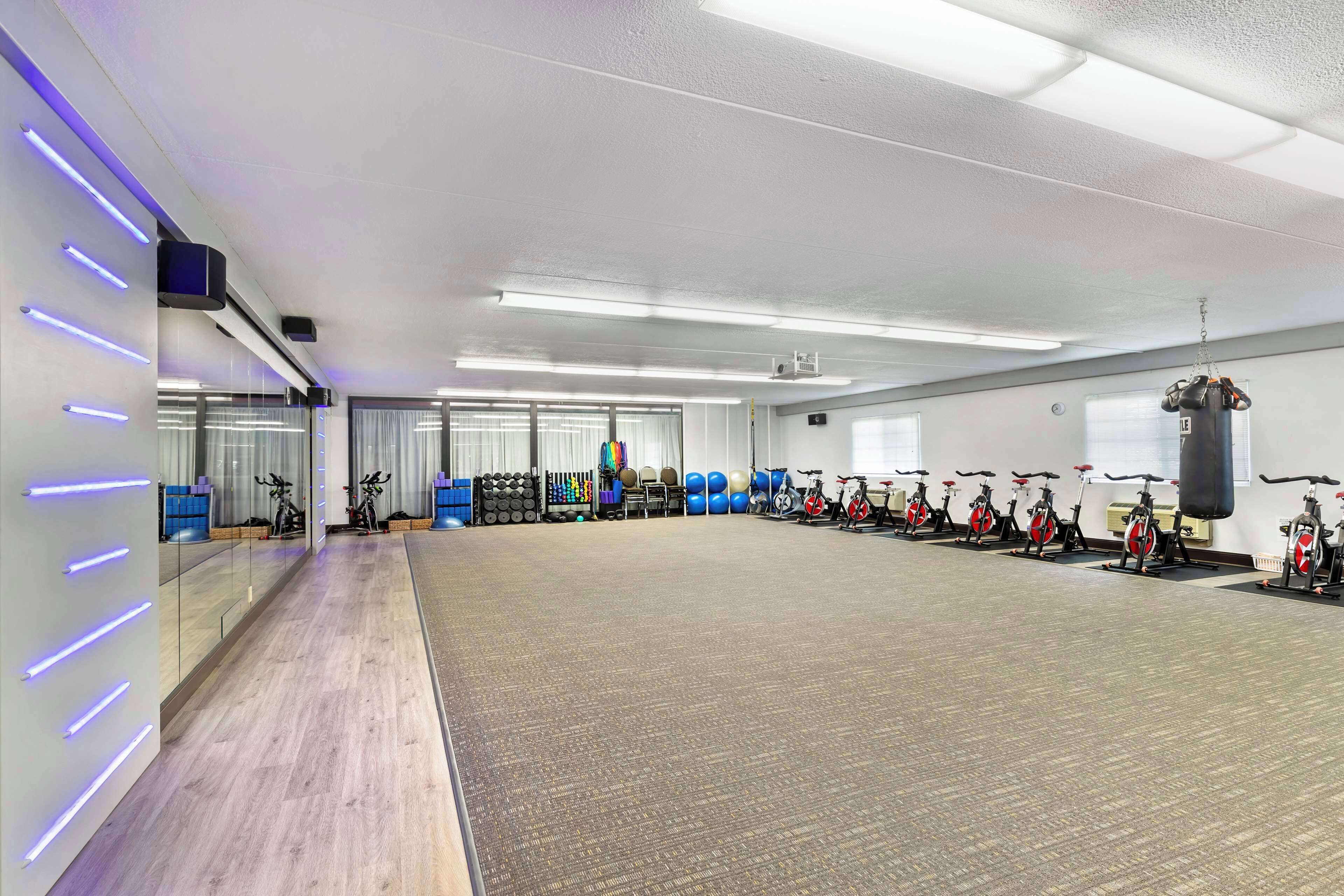 A spacious gym with exercise bikes, a punching bag, and various fitness equipment.