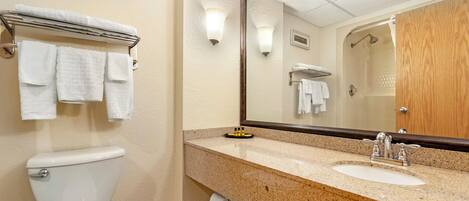 Une salle de bain avec des toilettes, un lavabo et un miroir.
