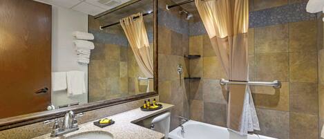 A bathroom with a double sink, a toilet, a bathtub, and a shower.