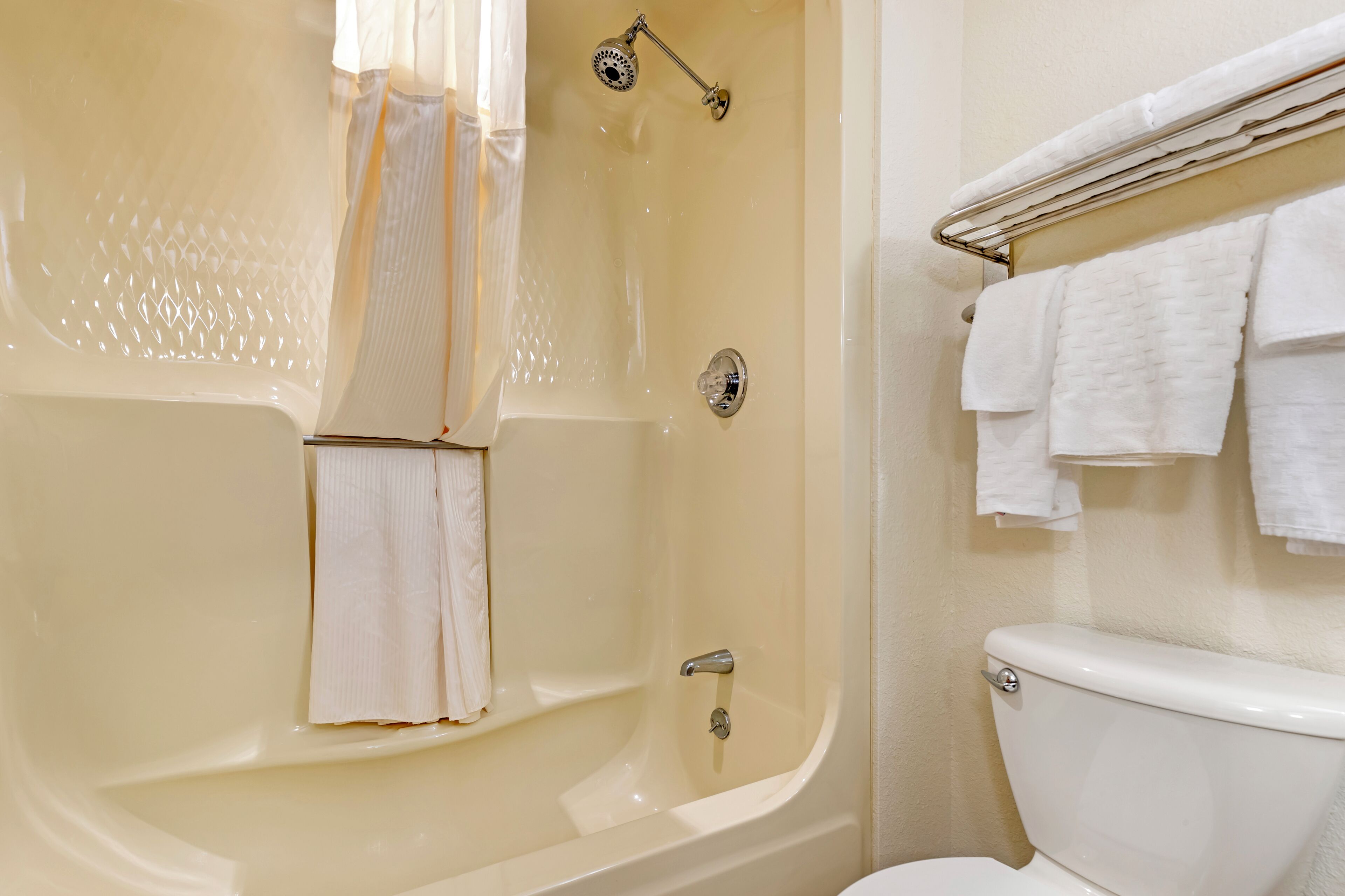 Une salle de bain équipée d’une baignoire, de toilettes et d’un porte-serviettes avec plusieurs serviettes.