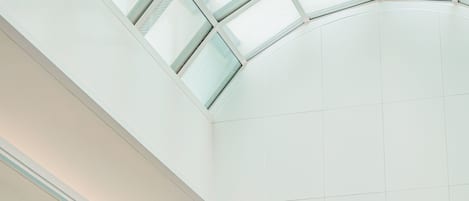 Un interior moderno con tragaluces, iluminación empotrada y un techo curvo.