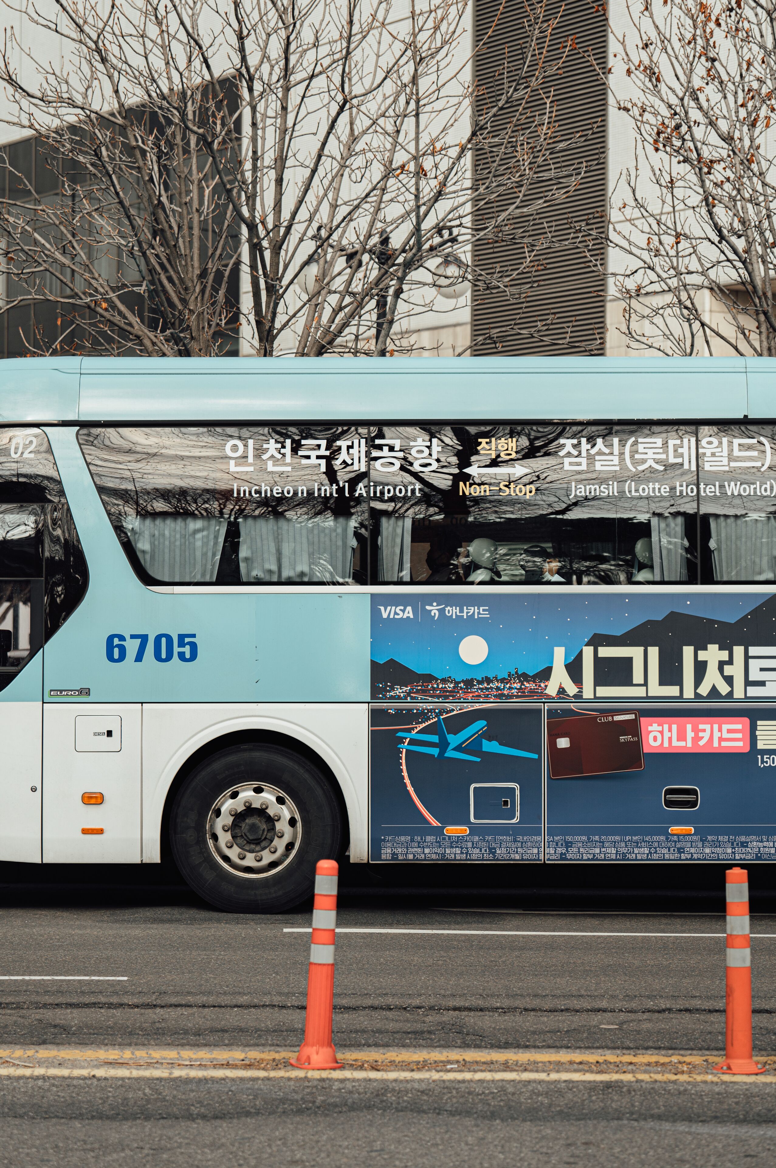 Un autobús con texto coreano publicitando el Aeropuerto Internacional de Incheon y el Jamis Hotel World.