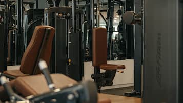 A gym with various exercise machines and equipment.
