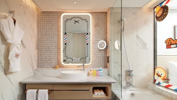 A modern bathroom with a marble sink, a mirror with barber shop branding, and a glass-enclosed shower.