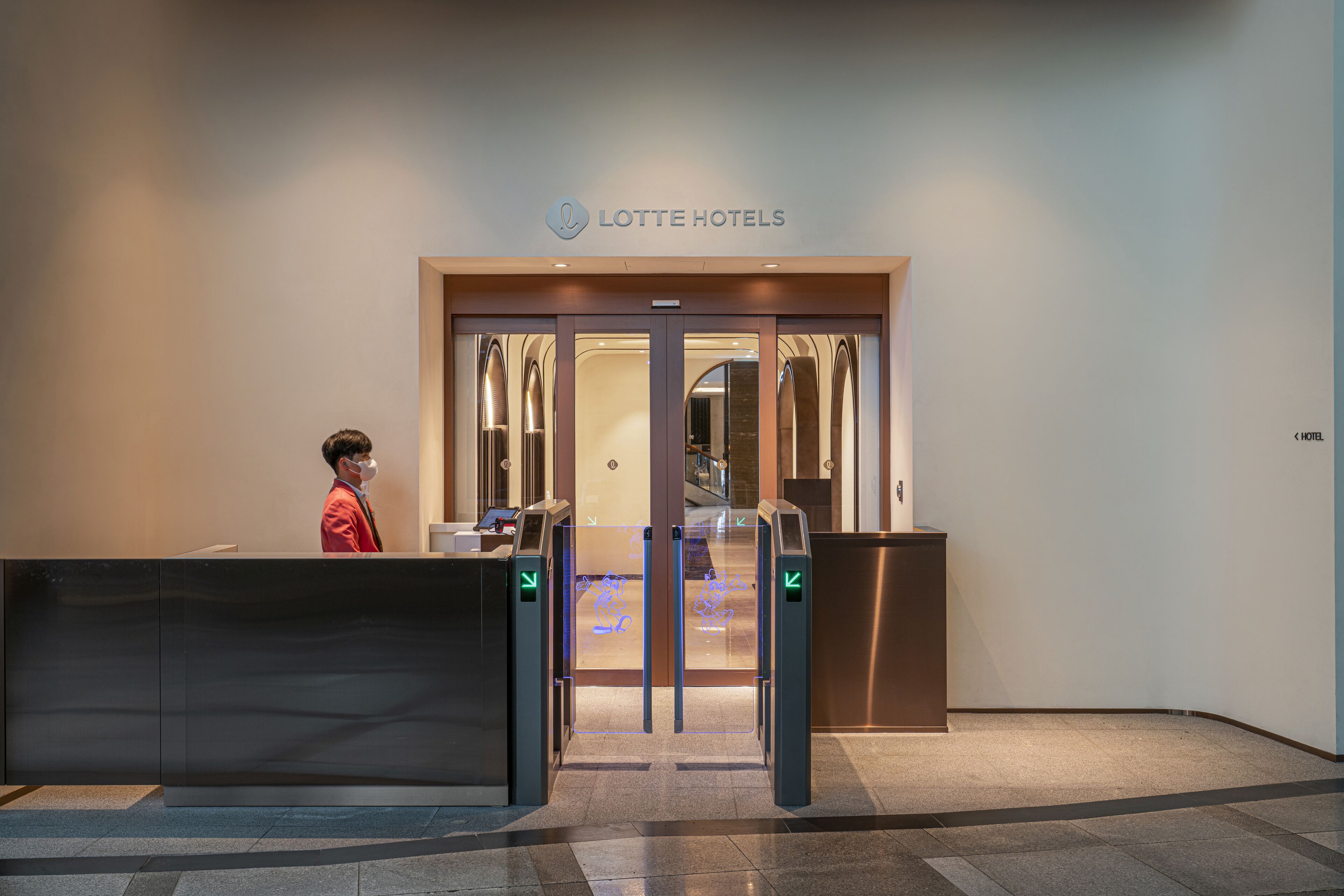 Een hotelentree met een receptiebalie, een bord met daarop 