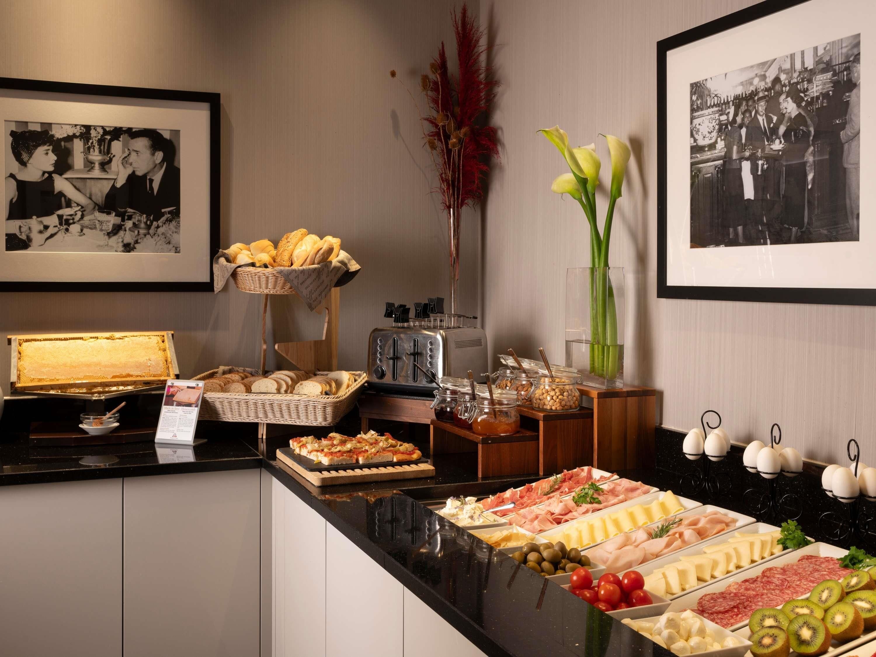 A buffet with various food items, a honeycomb display, and framed photographs on the wall.