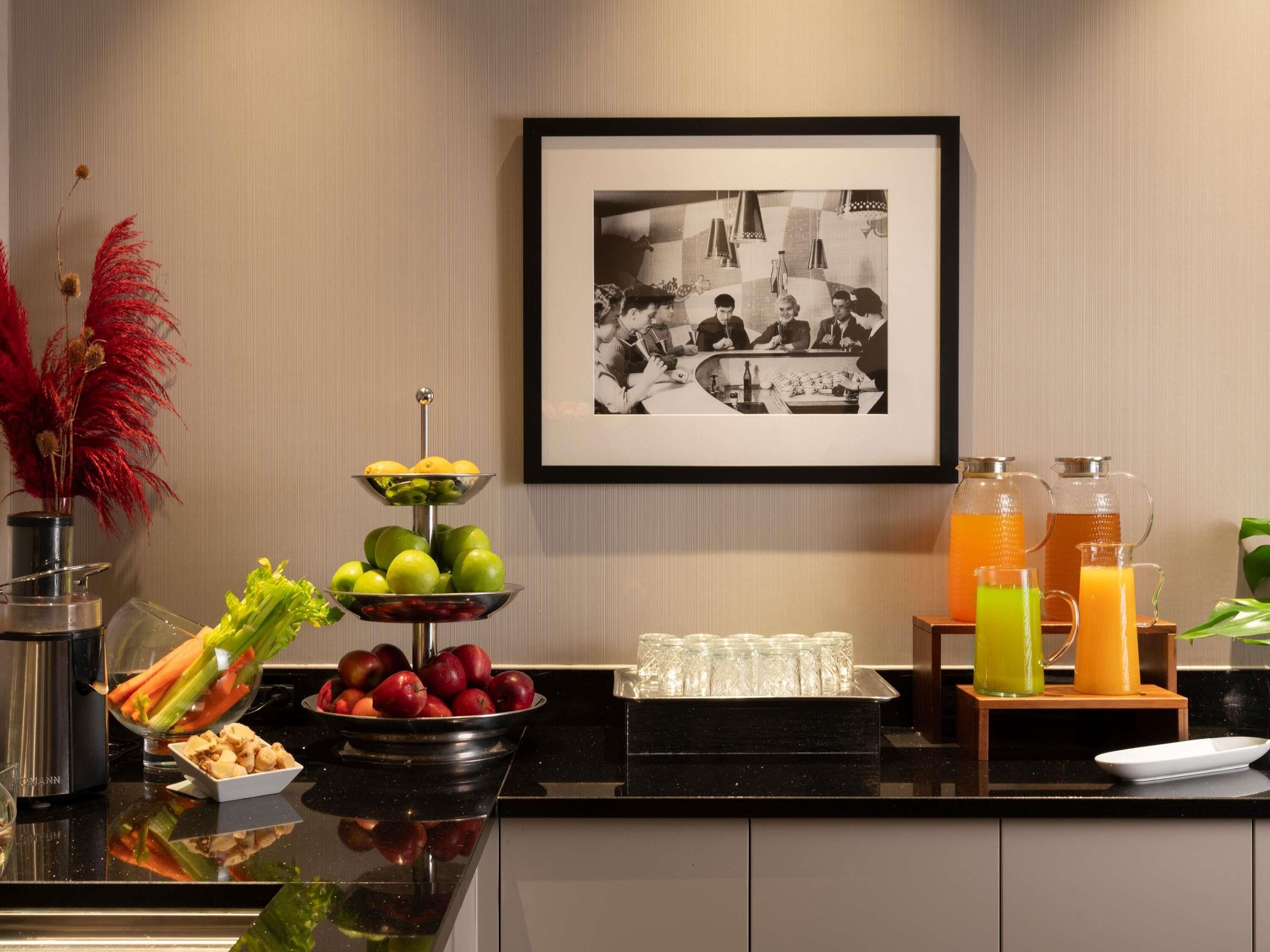A buffet setup with fruits, vegetables, and beverages.