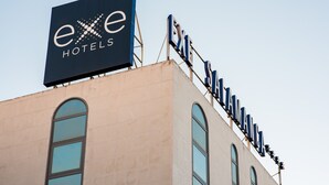 A hotel sign with the name "exe Hotels" and a series of letters spelling out "EXE" on the building's facade. - Exe Salamanca (Salamanca)