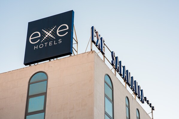 Un cartel de hotel con el nombre 'exe Hotels' y una serie de letras que deletrean 'EXE' en la fachada del edificio.