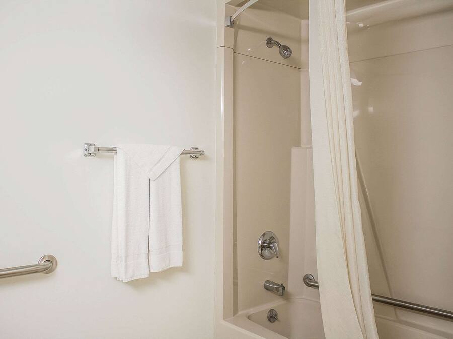 A bathroom with a glass-enclosed shower, a towel rack, and a grab bar.