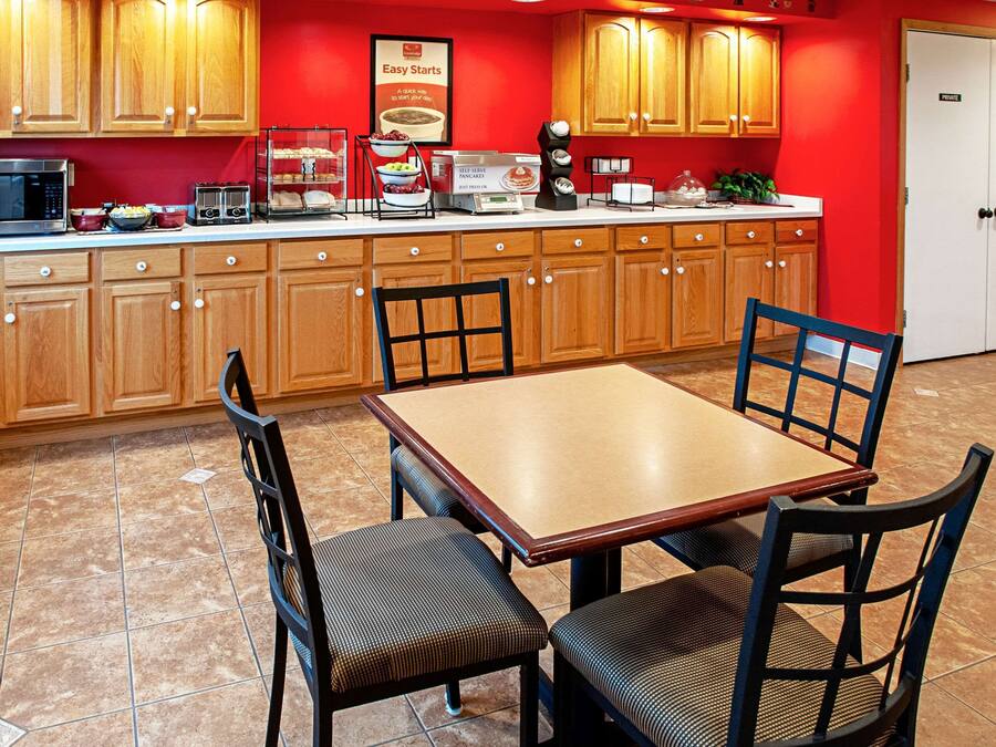 A kitchen with wooden cabinets, a microwave, a toaster, and a coffee maker.
