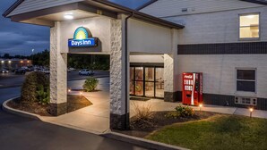 Un hôtel Days Inn doté d’un distributeur automatique de Coca-Cola, d’une zone de service au volant et d’une entrée bien éclairée.