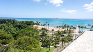 Une station balnéaire dotée d’une plage, de palmiers et offrant une vue dégagée sur l’océan.