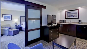 Habitación de hotel con sofá, televisión, cafetera y microondas.