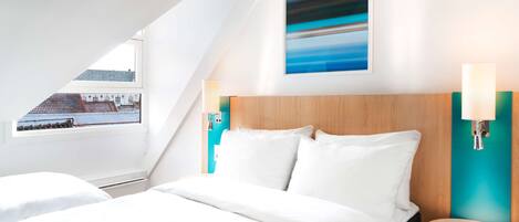Una habitación de hotel moderna con una cama grande, cabecera de madera, vista de la ciudad a través de un tragaluz y un cuadro en la pared.