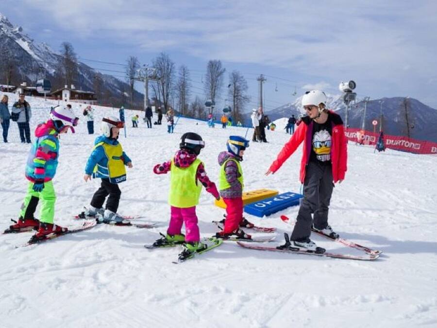 A ski slope with skiers and a person in a red jacket.