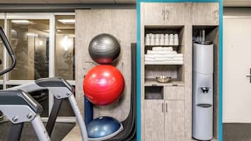 Espaço fitness com equipamentos de exercício, dispensador de água e armário com toalhas.